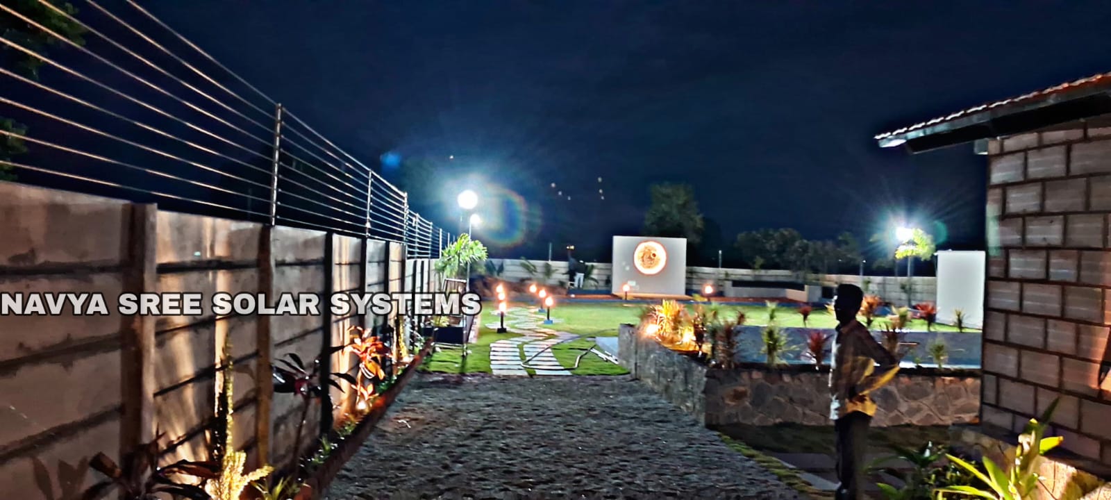 Night view of landscaped property secured with solar fencing