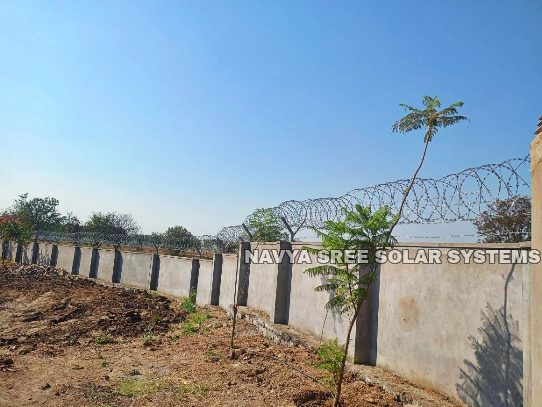 Long boundary wall with razor blade fencing