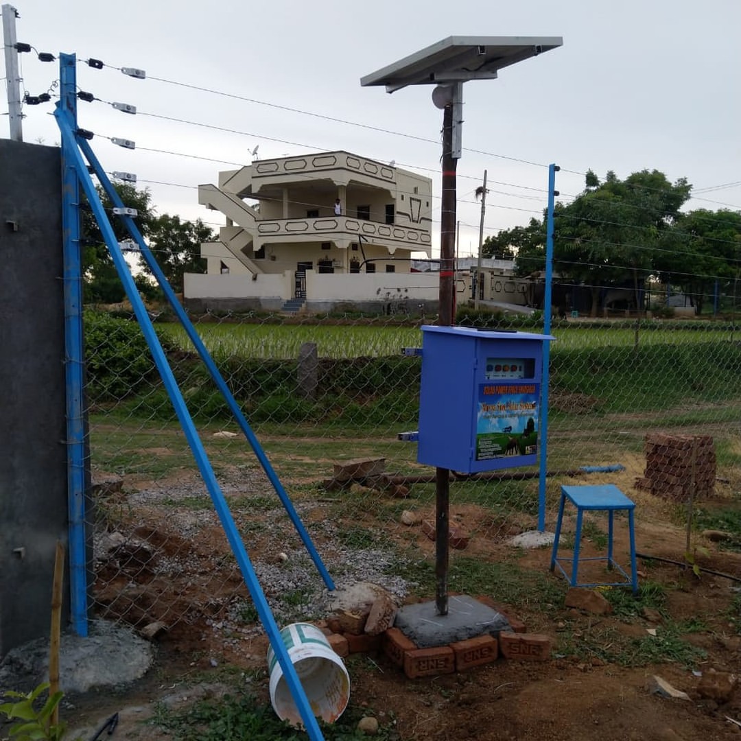 Solar energizer unit installed beside farmhouse fence